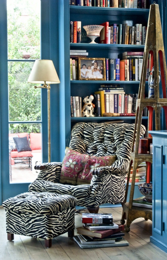 An étagère found by the client in a Magazine Street antique shop sits next to a mod zebra upholstered chair with vintage pillow.