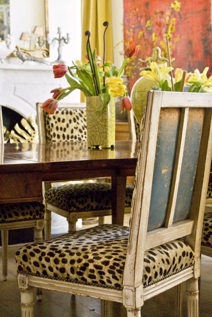 Worn antique blue leather on the backs of dining room chairs is revved up with leopard on the front.